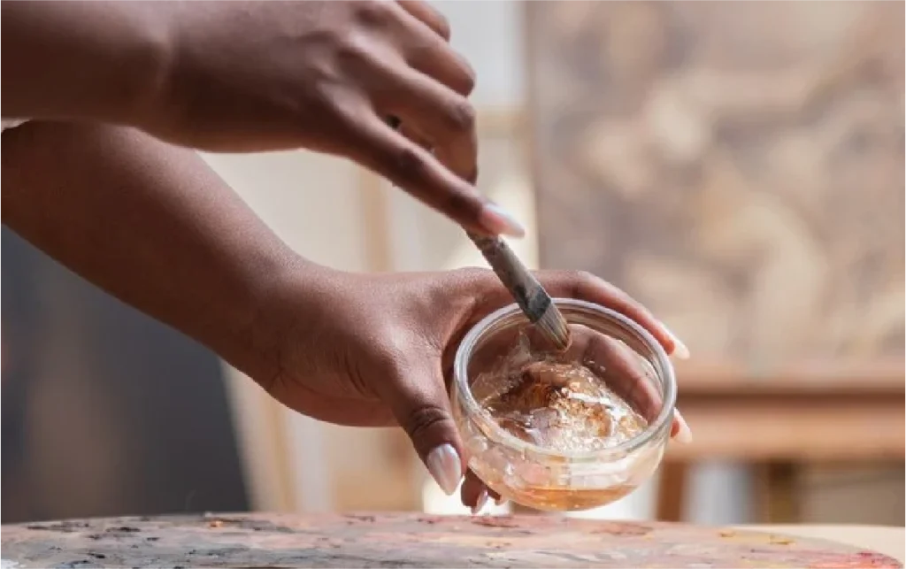 Photo des mains de l'artiste entrain de peindre.